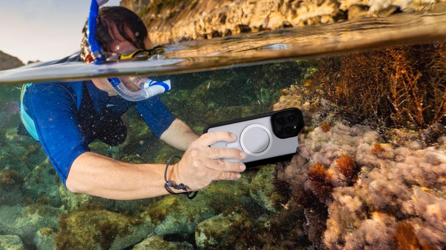 A diver takes pictures in the water with an iphone 15 pro max equipped with a waterproof phone case